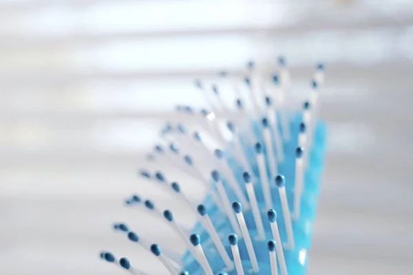 Blue and white comb on a light background, macro photo, selective art focus — Stock Photo, Image