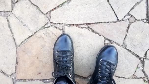 Μαύρες Δερμάτινες Μπότες Στο Πέτρινο Πάτωμα Θέα Στην Κορυφή — Αρχείο Βίντεο