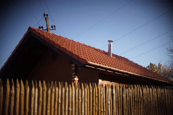 Дерев'яний будинок з червоним черепичним дахом і блакитним небом . — стокове фото