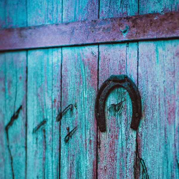 Velho ferradura de metal pendurado na porta de madeira azul — Fotografia de Stock