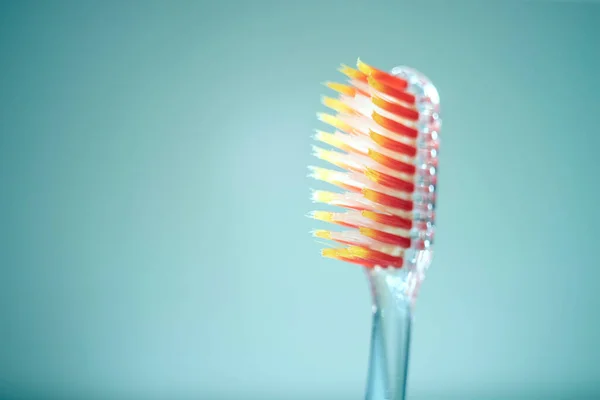 Turuncu Tüylü Şeffaf Plastik Diş Fırçası Açık Mavi Arkaplanda Yan — Stok fotoğraf