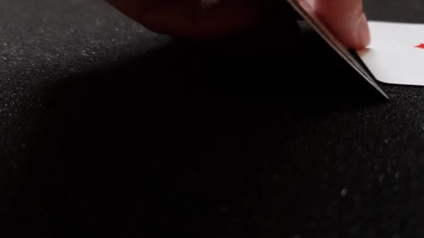 Vista lateral close-up de cartas ases mão colocada em uma mesa brilhante preto um de cada vez — Vídeo de Stock