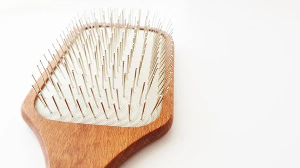 Escova de cabelo de massagem de madeira com cerdas de ferro na mesa branca, close-up, vista lateral — Fotografia de Stock