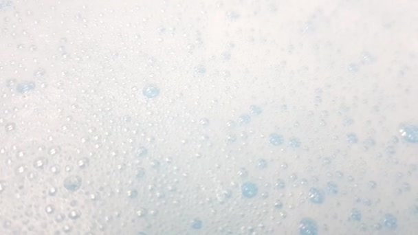 Água azul com espuma branca popping, vista close-up — Vídeo de Stock