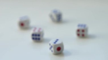 Beyaz bir masanın üzerinde farklı numaralar olan beş zar. Yan görünüm