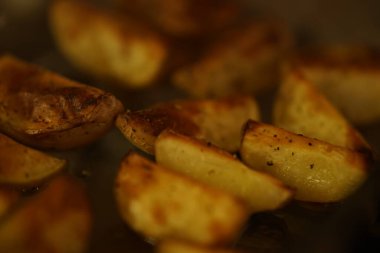 Yakın plan baharatlı fırında patates dilimleri..