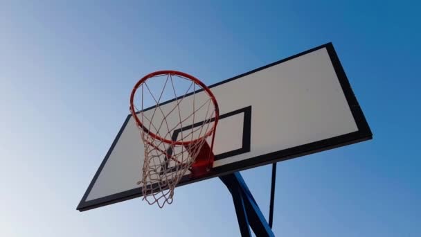 赤いバスケットボールフープオン青い空の背景 — ストック動画