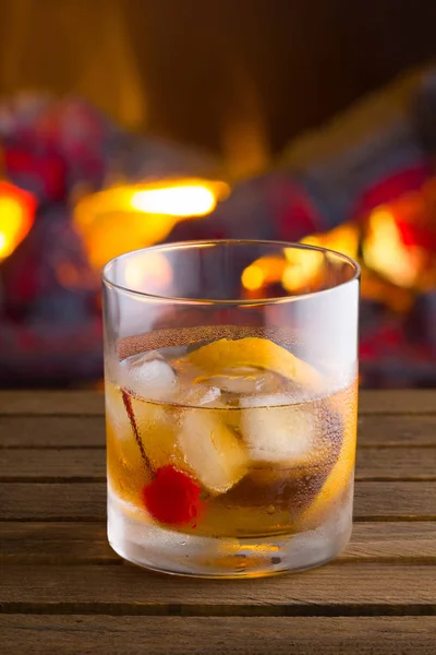 Old Fashion cocktail on fireplace background