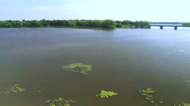 Hava görüntüsü nehri geçen köprüyü ve suda bir tekneyi gösteriyor.