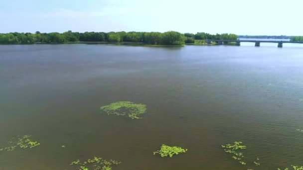 Вид с воздуха на мост, пересекающий реку, и лодку на воде — стоковое видео