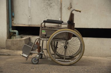 Duvara yakın otopark kahverengi bir tekerlekli sandalye