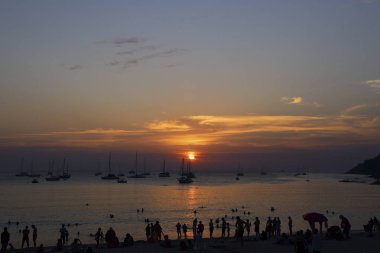 Phuket, Tayland-Ocak 2, 2016: Güzel gün batımı ve Nai Harn beach ve çok sayıda turist gökyüzüne