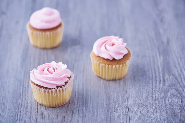 Três Deliciosos Cupcakes Rosa Fundo Madeira — Fotografia de Stock