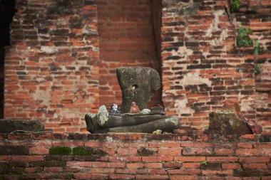 Eski Buda heykeli Ayutthaya tarihsel Park'ta başı kesilmiş. Harabe duvarlar inşa arka plan.