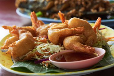 Bir tabak lezzetli kızarmış karides topları masanın üzerine sos ile