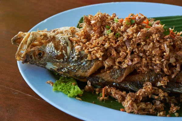 Lezzetli sıcak kızarmış deniz levreği mavi plaka restoran sarımsak biber ile