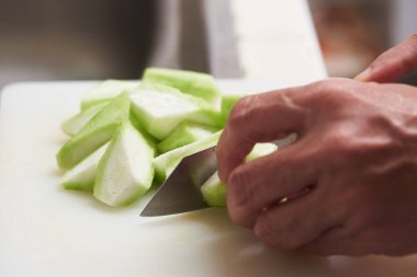 Yiyecek hazırlama için beyaz Doğrama tahtası üzerinde kabak doğrama mutfak bıçağıyla