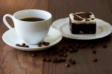 Bir fincan kahve ve çikolata kek üzerine ahşap masa