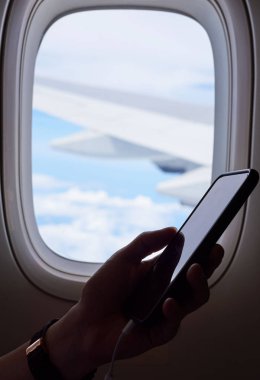 Pencerenin istimal hareket eden telefon uçak içinde bir adam