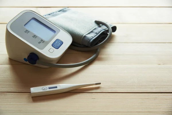 Een witte thermometer en de bloeddrukmeter op houten achtergrond — Stockfoto