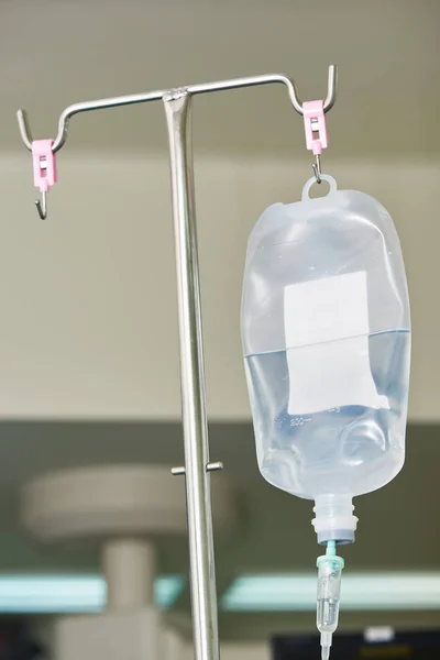 Um fluido intravenoso pendurado no poste — Fotografia de Stock