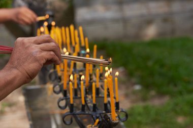 İnsanlar mumlardan tütsü yakan eller