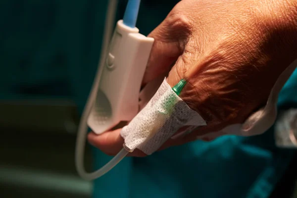 Игла для вливания жидкости в руку пациента в операционной — стоковое фото
