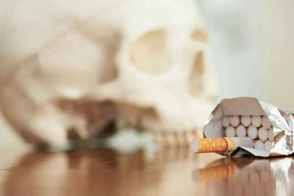 Concepto de alerta sanitaria demostrando el cráneo humano y el tabaco . — Foto de Stock