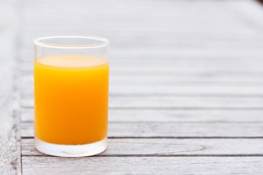 Ahşap masa üzerinde portakal suyu bir bardak 