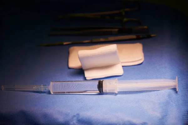 Spruta och nål, Flor och kirurgiska instrument på bordet — Stockfoto
