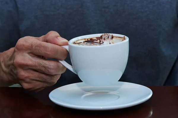 Mężczyzna posiadający smaczną filiżankę cappuccino — Zdjęcie stockowe