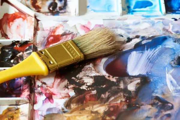 Geel schilderij borstel op water kleurenpalet — Stockfoto
