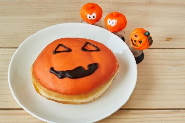 Ahşap masada bir tabak cadılar bayramı çöreği.