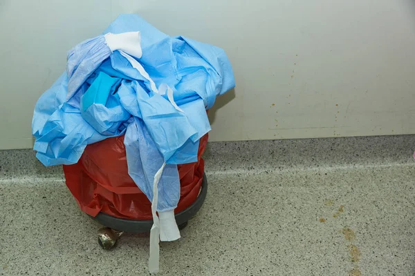 Blue surgical gowns in the garbage after finishing surgery in operating room