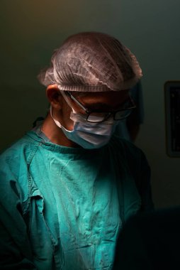 Ameliyathanede ameliyat yapan kıdemli bir Asyalı cerrah.
