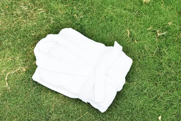 White terry bathrobe on green grass