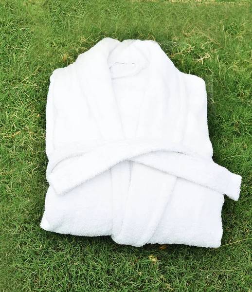 White terry bathrobe on green grass