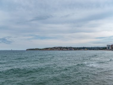 Yakınlarında yelkenliler olan sahil kasabaları. Çoğunlukla gökyüzünü ve etrafını saran denizi görebilirsiniz..