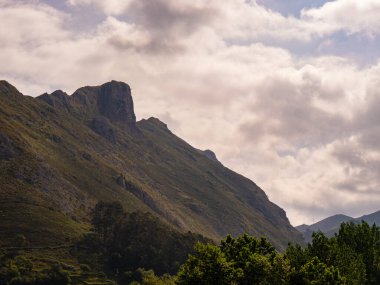 Büyük vadi ve dağlar. Çok fazla bulut var ve aralarında güneş ışıkları akıyor. Bu manzarayı rüya gibi aydınlatıyor..