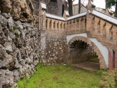 Merdivenlerin altında kemer olan bir geçit. Birçok malzeme ve doku, tuğla, ham taş, vb. Comillas 'taki (Cantabria, İspanya) Gaudi' nin Kaprisi 'nin bir detayı.).