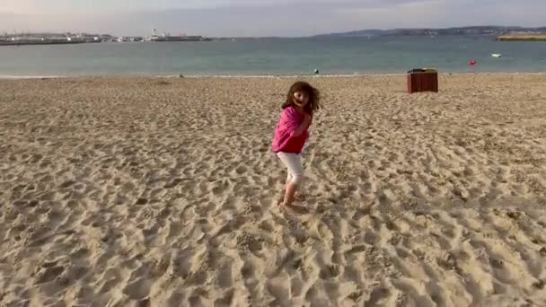 一个5岁的小女孩在海滩上奔跑 奔向水面 这是一个加利西亚海滩 气候有点冷 — 图库视频影像