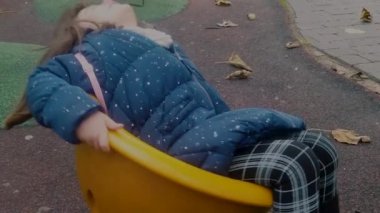 5 yaşında bir kız çocuk parkında oynuyor, yavaş çekimde dönüp duruyor..