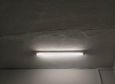 Tavandaki floresan tüpü damlacıklarla beyaz bir odayı aydınlatıyor..