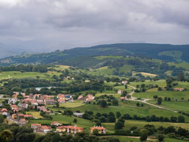 Bulutlu bir günde, dağlarla ve doğanın ortasındaki bir köyle panoramik manzara