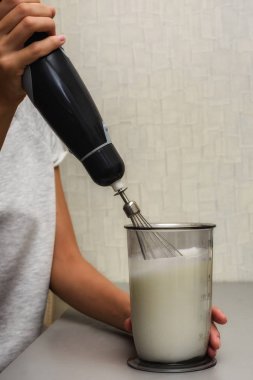      Kadın krem şanti karıştırıcıda yapar.