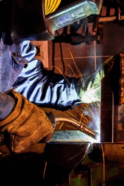 Kaynakçı üretim atölyesinde çelik yapılarda kaynak iş başında