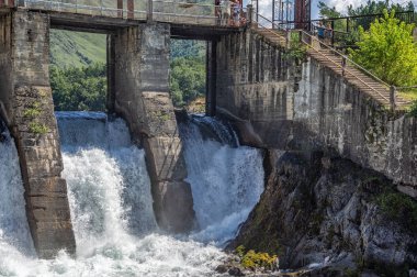 Dağ nehrindeki küçük bir barajdan sonra su akar.