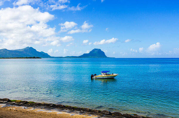 view of the sea beach on a Sunny summer day with a boat on the water