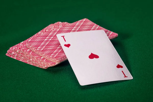 playing card ACE on an inverted deck of cards on a green table