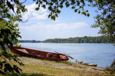 Nehrin yaz manzarası ve kıyıda bir tekne. Ob Nehri, Altai Krai, Rusya